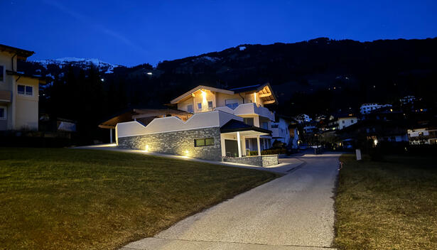 Haus Markus in der Abenddämmerung mit Aussenbeleuchtung am Haus und am neuen Anbau