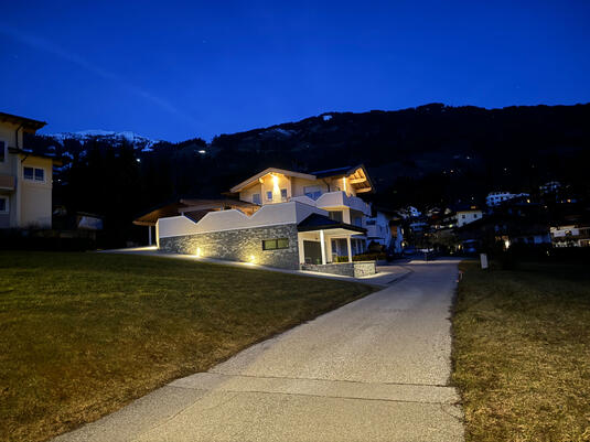 Haus Markus in der Abenddämmerung mit Aussenbeleuchtung am Haus und am neuen Anbau
