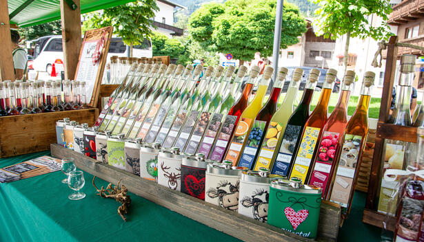 Bauernmarkt am Schloss in Fügen mit verschiedenen traditionellen Getränken auf einem Tisch.